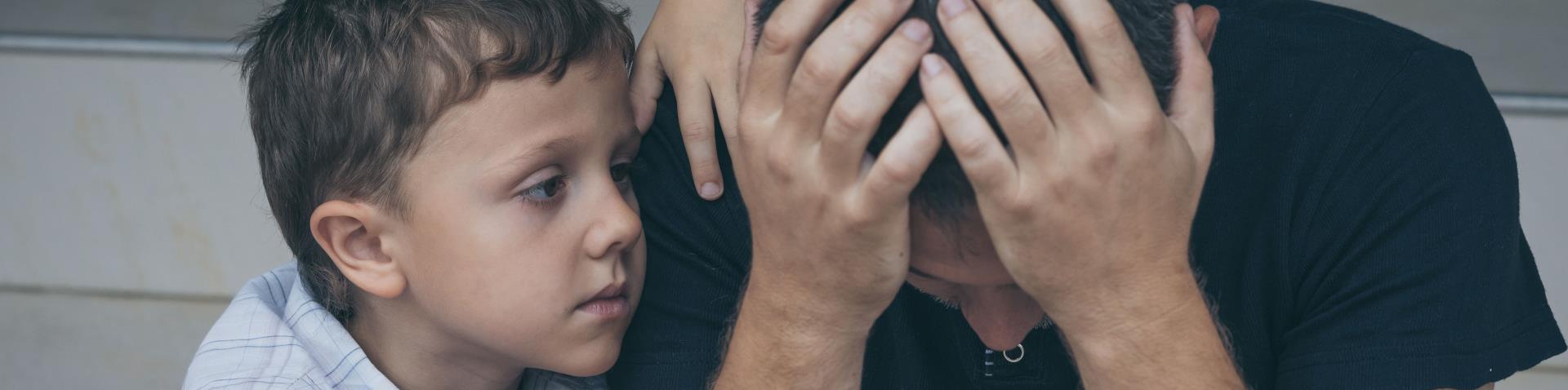 Portrait of young sad little boy and father sitting outdoors at the day time v4